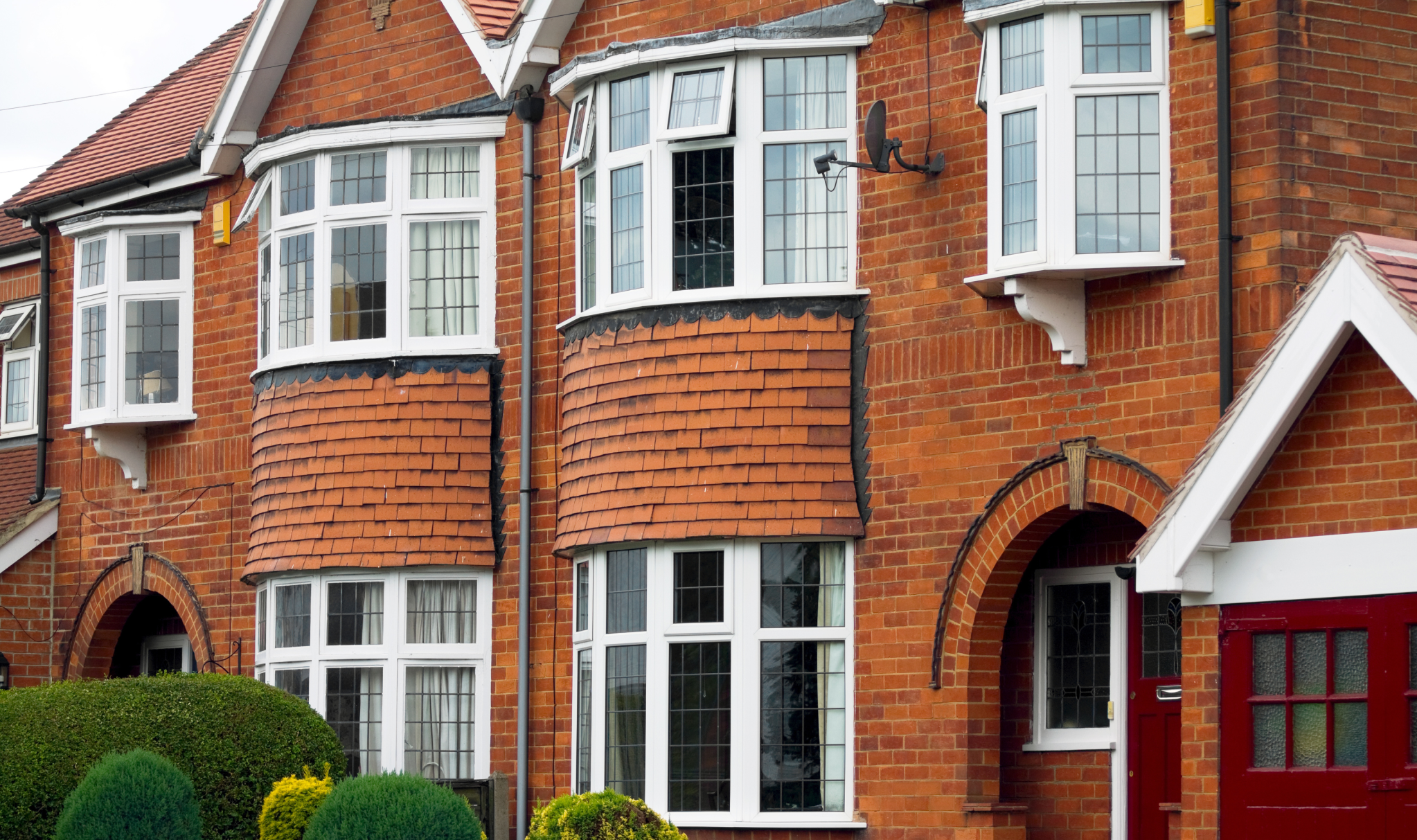 Row Of Red Brick Houses With Red Garage Door